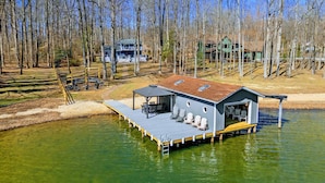 Un chalet au bord du lac, doté d’un quai, d’un espace salon abrité et d’une grande terrasse ouverte.