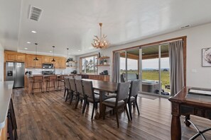 Una cocina amplia con armarios de madera, una isla grande y una zona de comedor con sillas.