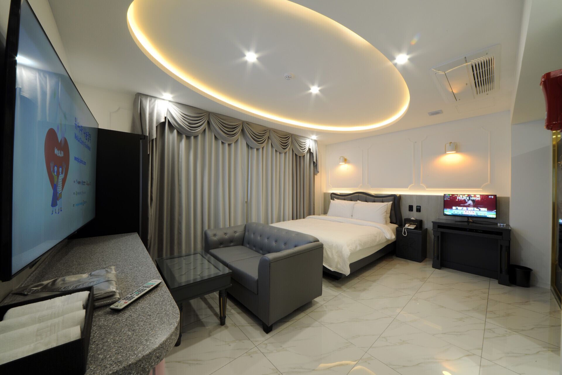 Une chambre d’hôtel moderne équipée d’un lit, d’un canapé, d’une télévision et d’un bureau.