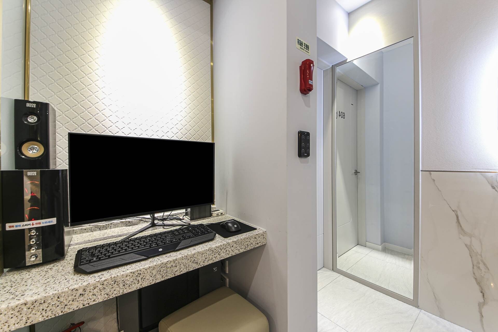 Une salle de bain avec une douche, des toilettes, un lavabo équipé d’un clavier et un téléviseur.