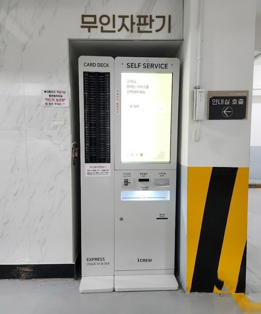 A self-service kiosk with a card deck and a screen displaying instructions in Korean.