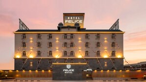 Ein Hotel mit auffälligem Schild, auf dem 'HOTEL FELICE' steht, zahlreichen Fenstern und einem großen Eingang.
