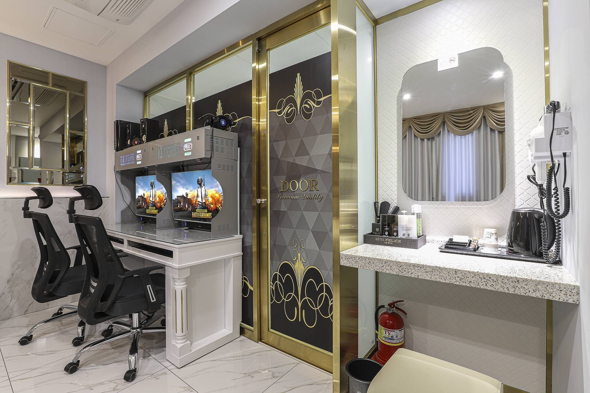 A modern hotel room with a gaming station, a vanity with a mirror, and a minibar.