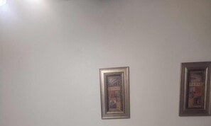 Kaksi kehystettyä kuvaa tavallisella seinällä.