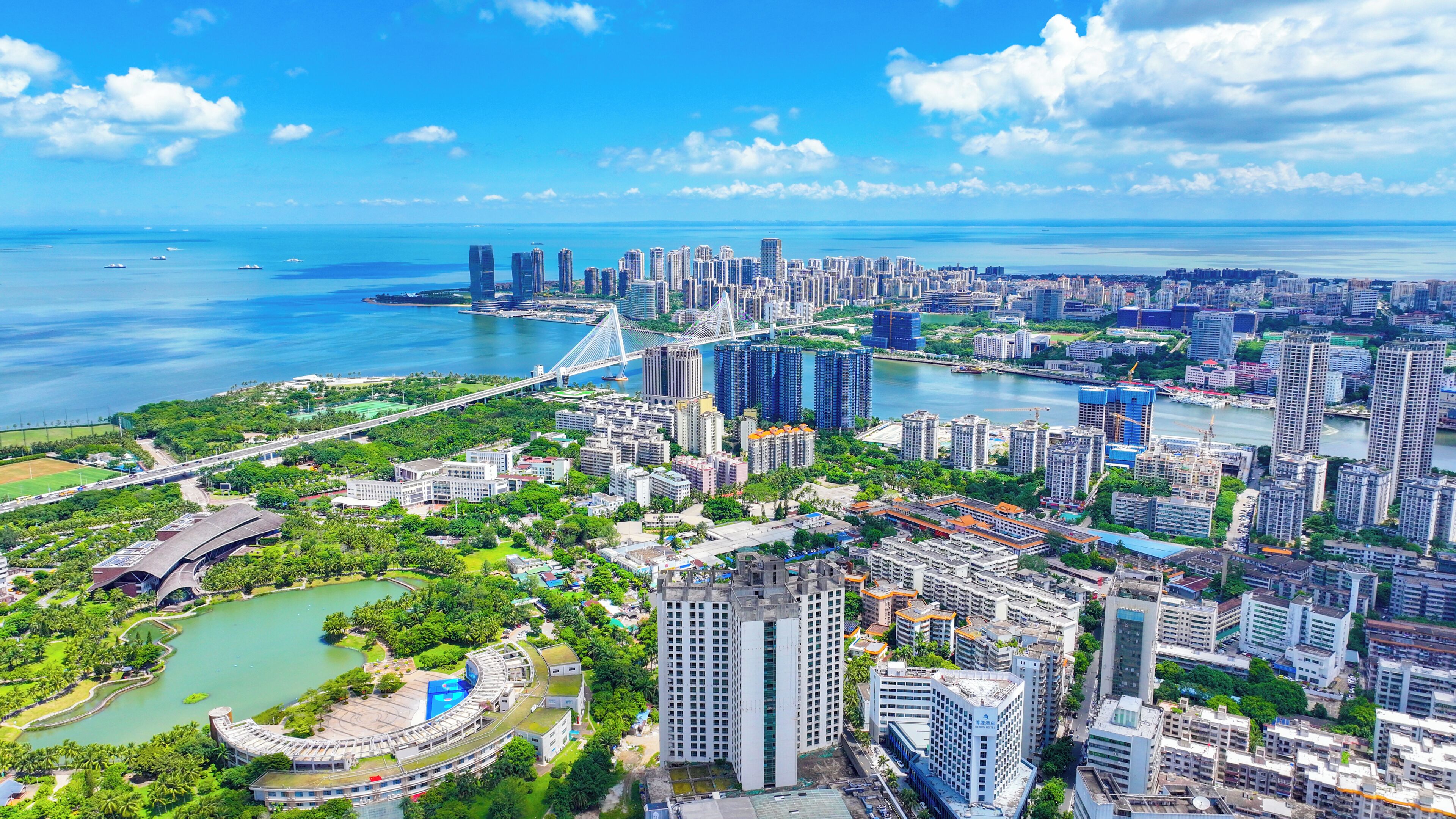 A cityscape with high-rise buildings, a bridge, and a body of water.