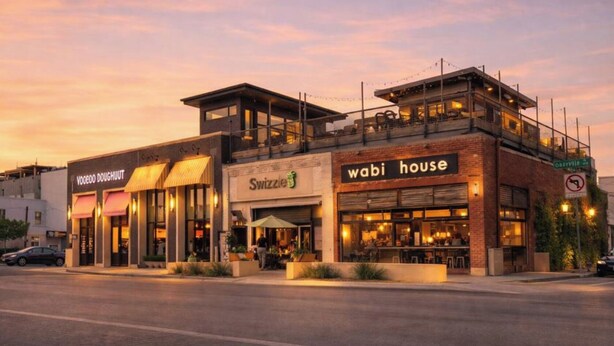 Um edifício com fachada que exibe as placas 'Swizzle House' e 'Voodoo Doughnut'.
