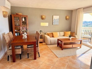 A living room with a dining table, chairs, a sofa, and a coffee table. - Arrive & feel at home! Newly renovated apartment in a quiet location (Porto Cristo Novo)