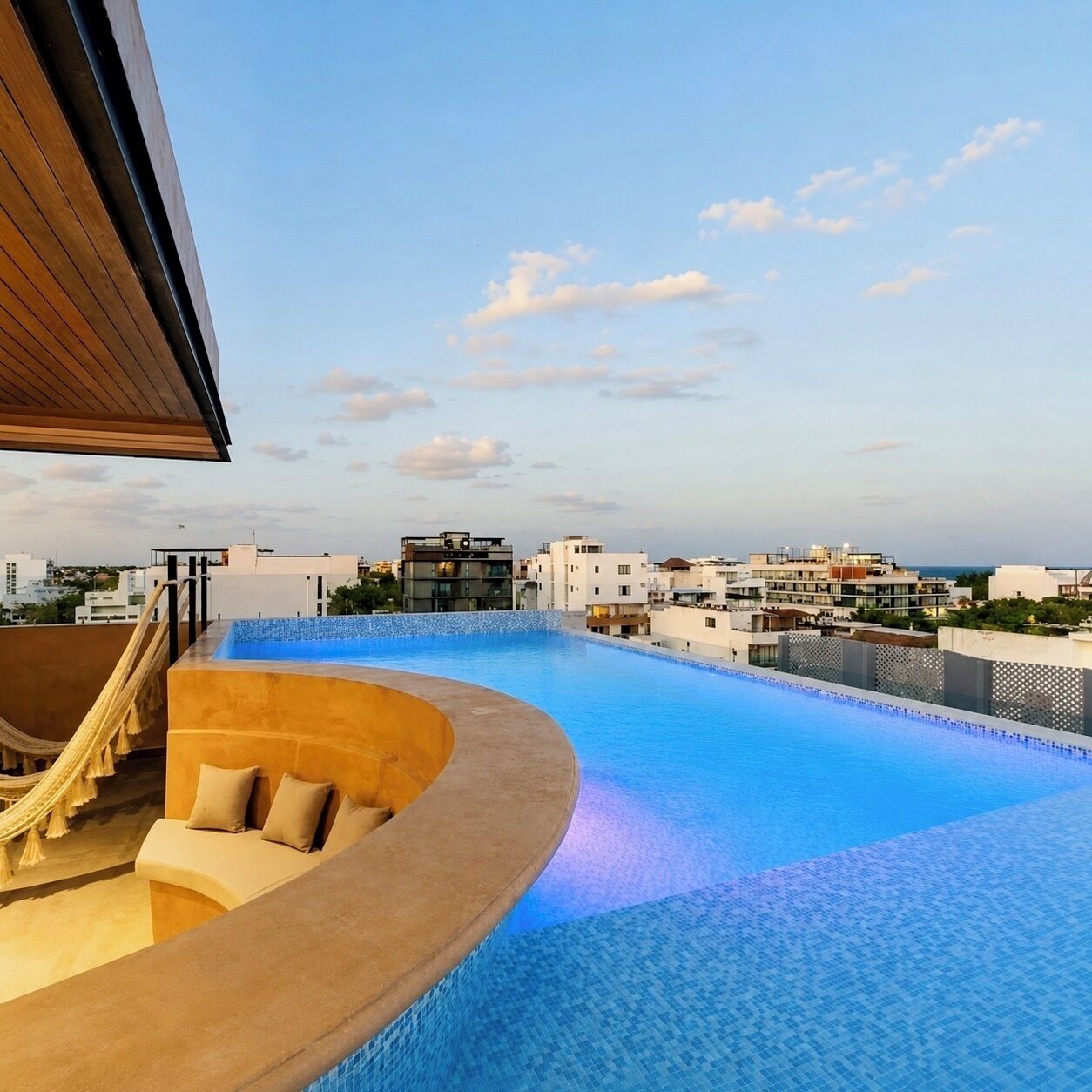 A rooftop infinity pool with a view of the city skyline.