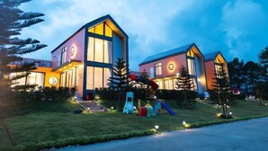 A modern two-story building with a flat roof, large windows, and a well-lit entrance. - MK Land Pool Villa Khaokho (Khao Kho)