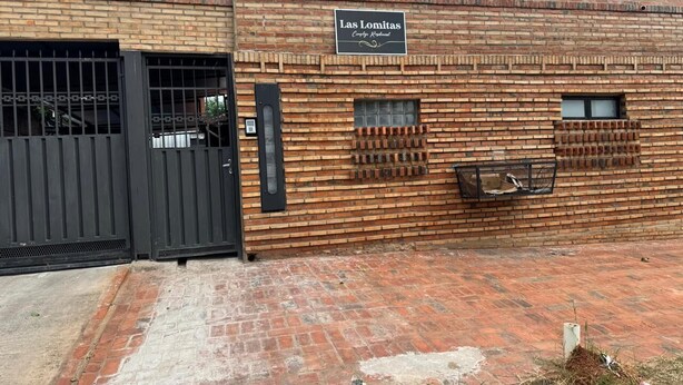 A brick building with a sign reading 'Las Lomitas.' - Las Lomitas Residence (Ñemby)