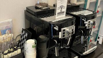 Angolo caffè con diverse macchine espresso, cialde e bicchieri usa e getta.
