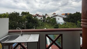 A balcony with a sink, overlooking a residential area with houses and greenery. - Airport Residencies (Katunayake)