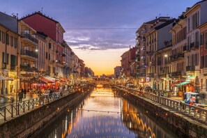 A canal with buildings on either side, a bridge in the middle, and lights reflecting on the water. - Elegant Loft in Citylife Wifi - A/C - (Milan)