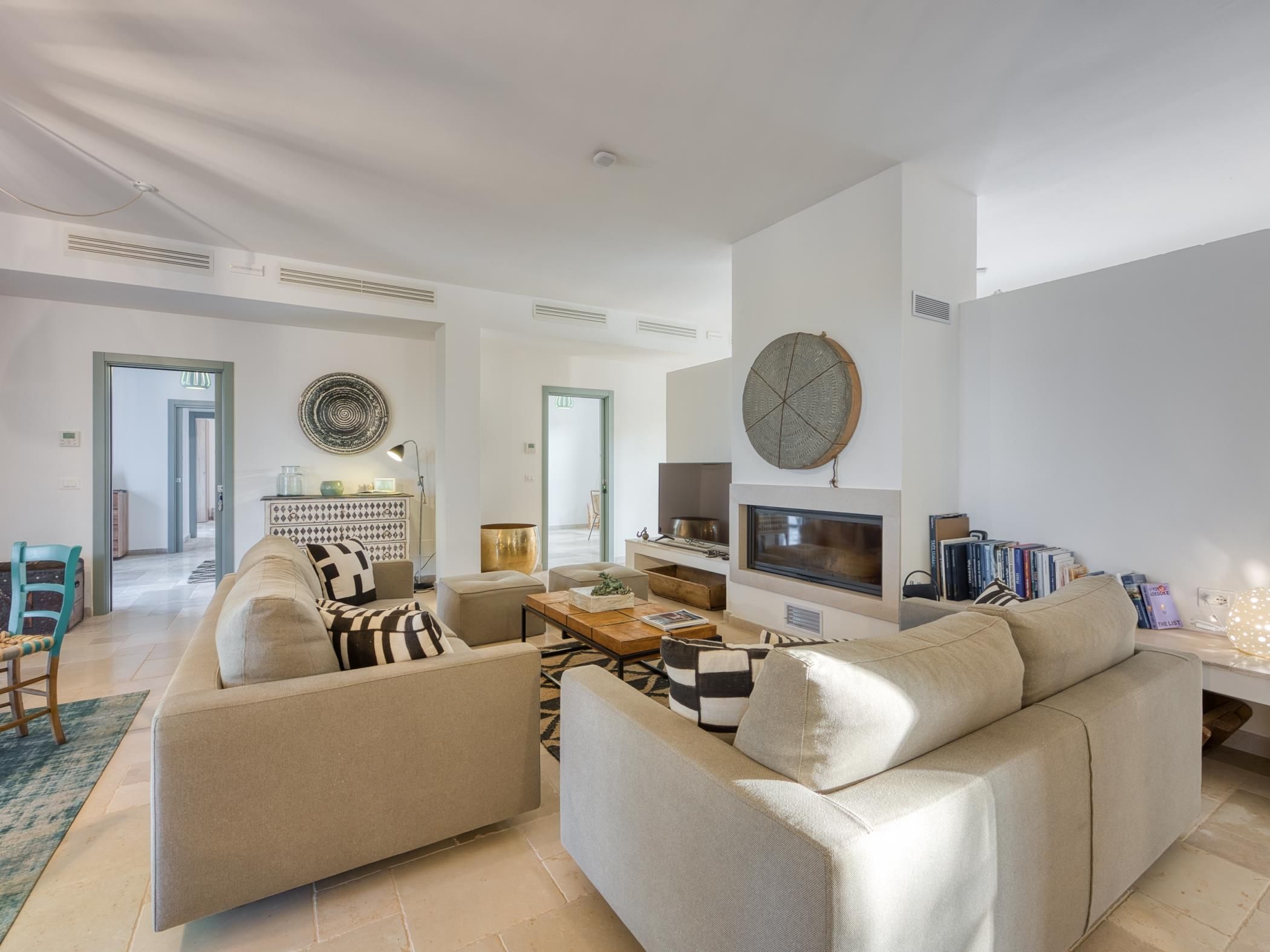Un salon moderne avec un canapé, une table basse et un téléviseur à écran plat.