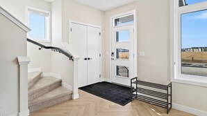 A modern interior with a staircase, a black doormat, and a metal rack. - Perfect 3-bedroom house in lovely Calgary for your getaway (Calgary)
