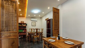 A dining area with wooden furniture, a clock, and a shelf with beverages. - ManBuYunDuan.Theme Inn (Xinzhou)