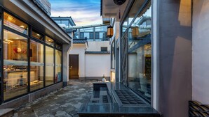 A courtyard with a stone floor, a small table, and a lantern. - ManBuYunDuan.Theme Inn (Xinzhou)