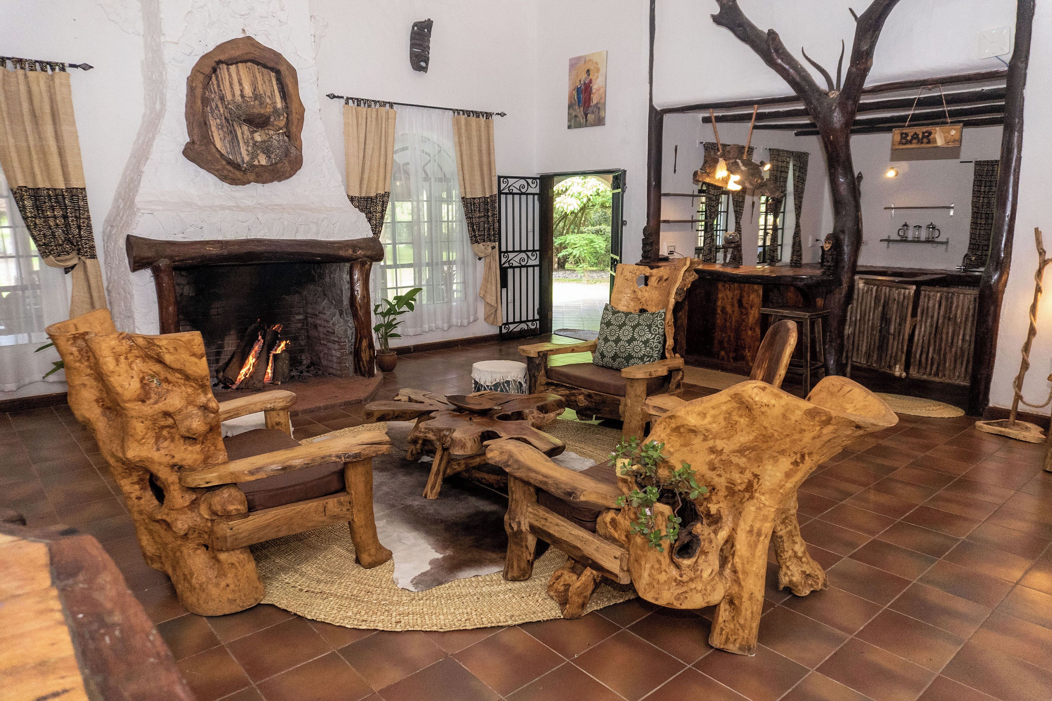 A rustic interior with a fireplace, wooden furniture, and a bar area.