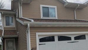 A two-story house with a garage, a front door, and a visible house number 401. - Superb 3-bedroom condo in Wellman within walking distance from two playgrounds. (Wellman)