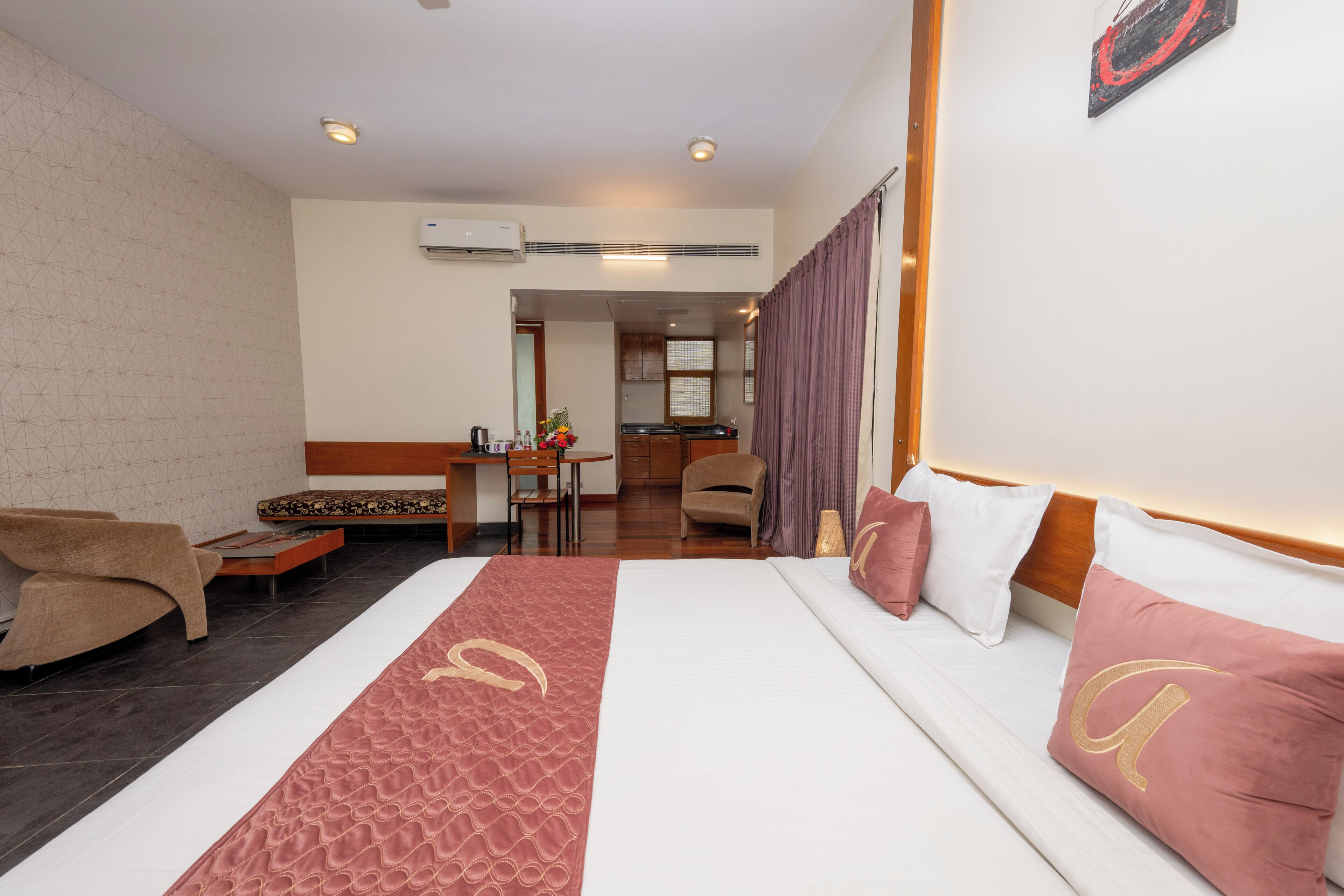 A hotel room with a bed, a sofa, a desk, and a chair.