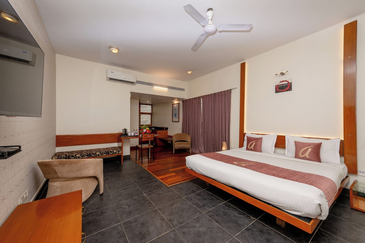 Une chambre d’hôtel équipée d’un lit, d’un bureau, d’une chaise, d’un ventilateur de plafond et d’un appareil de climatisation.
