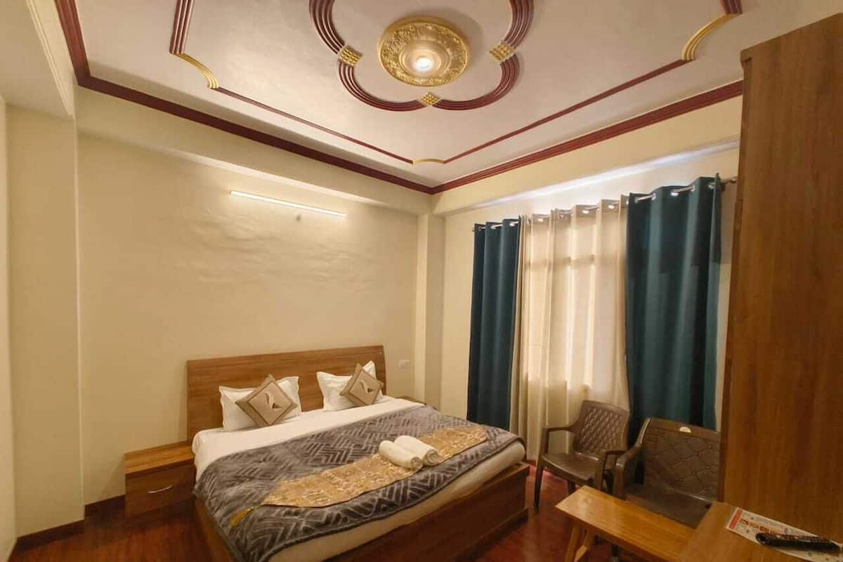 A hotel room with a wooden bed, a desk, and a chair.