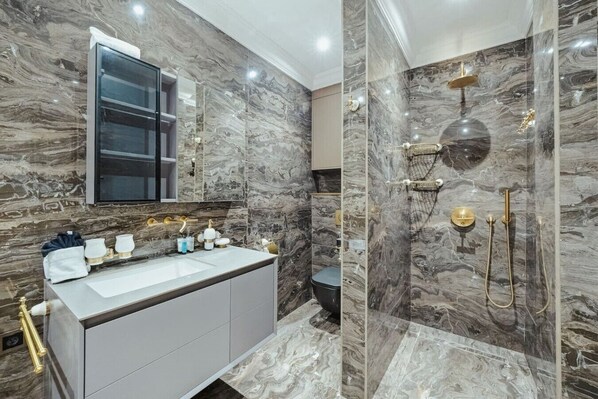 A modern bathroom with a marble vanity, a glass shower enclosure, and a large mirror. - Bocobay Aruba Racquet Club (Noord)