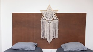 A room with two beds, a brown headboard, and a macramé wall hanging. - Casa Rebeca3 Complete, ideal for large groups, work teams, vacations, etc. (Chihuahua)