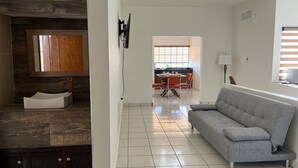A living room with a gray sofa, a wooden accent wall, and a tiled floor. - Casa Rebeca3 Complete, ideal for large groups, work teams, vacations, etc. (Chihuahua)