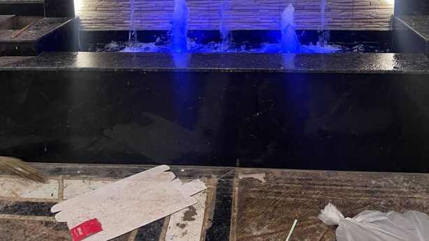 A modern indoor water feature with three jets, set against a textured wall with a wooden panel backdrop. - Royal Classic Hotel (Digha)