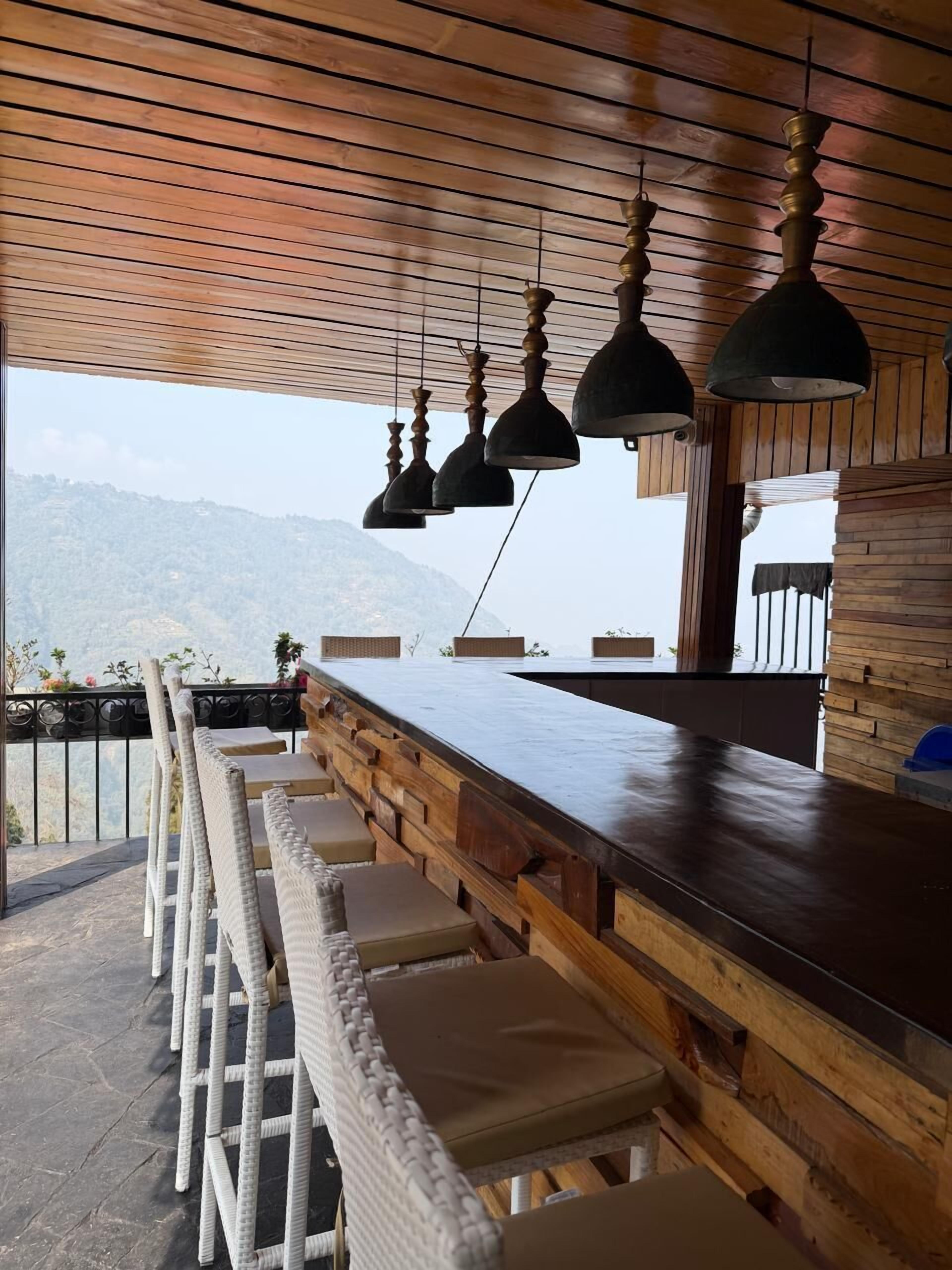 A bar area with wicker chairs and a wooden counter.