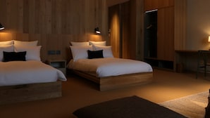 A modern bedroom with two beds, wooden walls, and a desk. - HACIENDA KARUIZAWA HOTEL (Karuizawa)