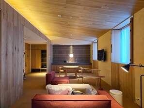 A modern living room with a wooden ceiling, a dining area, and a kitchen with a large window. - HACIENDA KARUIZAWA HOTEL (Karuizawa)