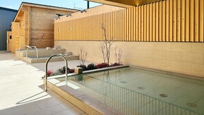 A modern indoor pool area with a wooden wall, a glass pool, and a metal staircase. - HACIENDA KARUIZAWA HOTEL (Karuizawa)