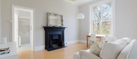 Una sala de estar moderna con chimenea, un sofá blanco y un comedor.