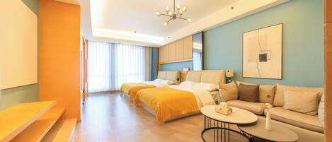 A hotel room with a bed, a sofa, a small table, and a ceiling light.