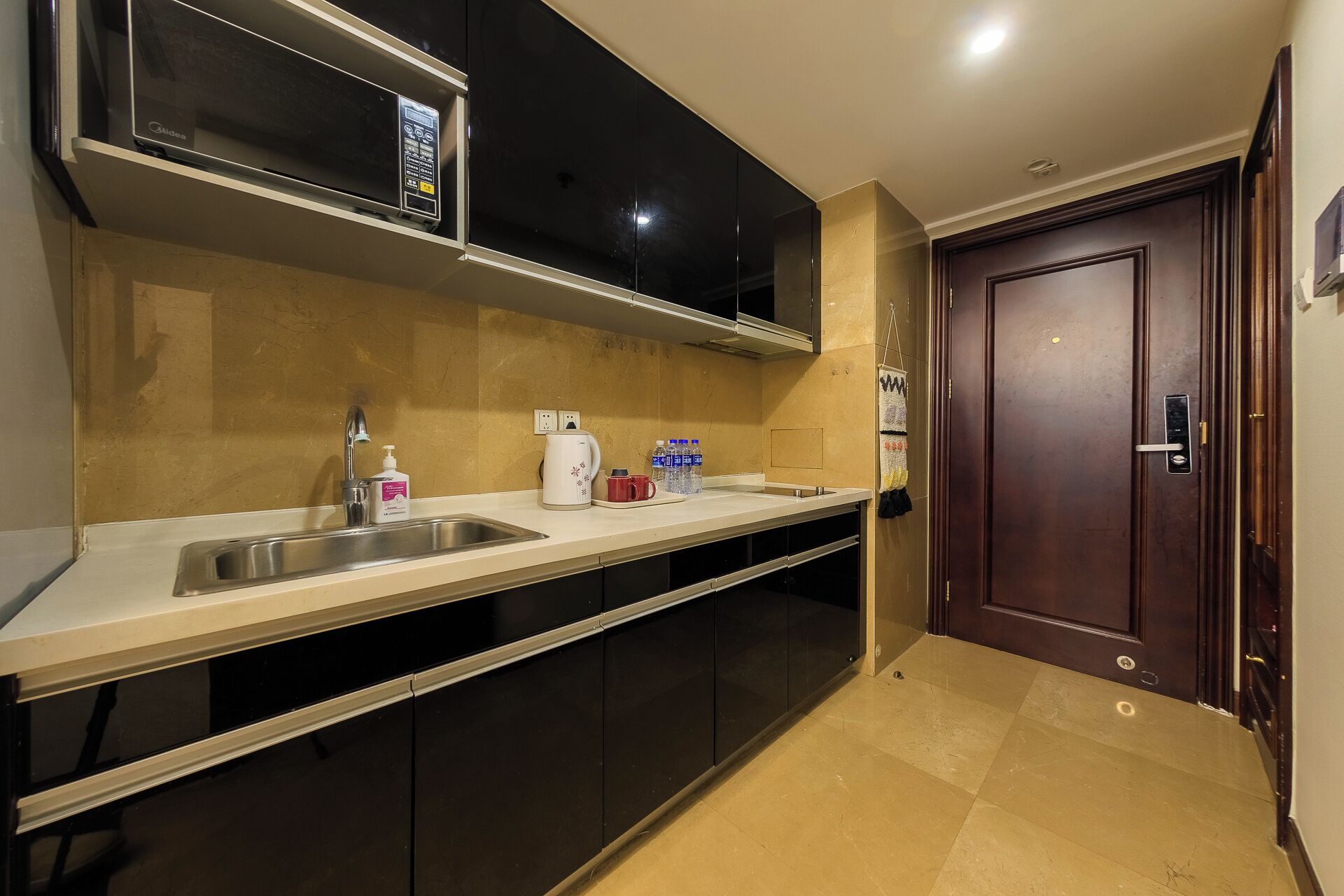 A modern kitchen with a stainless steel sink, a microwave, and a coffee maker.
