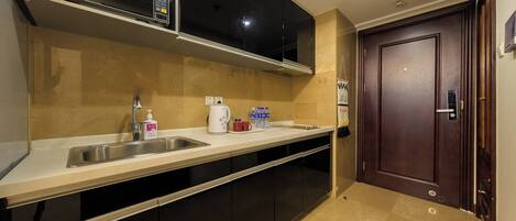 A modern kitchen with a stainless steel sink, a microwave, and a coffee maker.