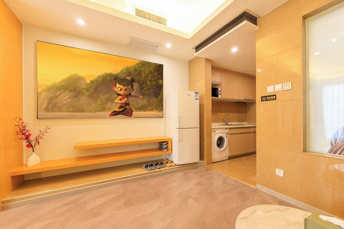 Une chambre d’hôtel moderne dotée d’une grande télévision à écran plat, d’un lave-linge et d’un petit coin salon.