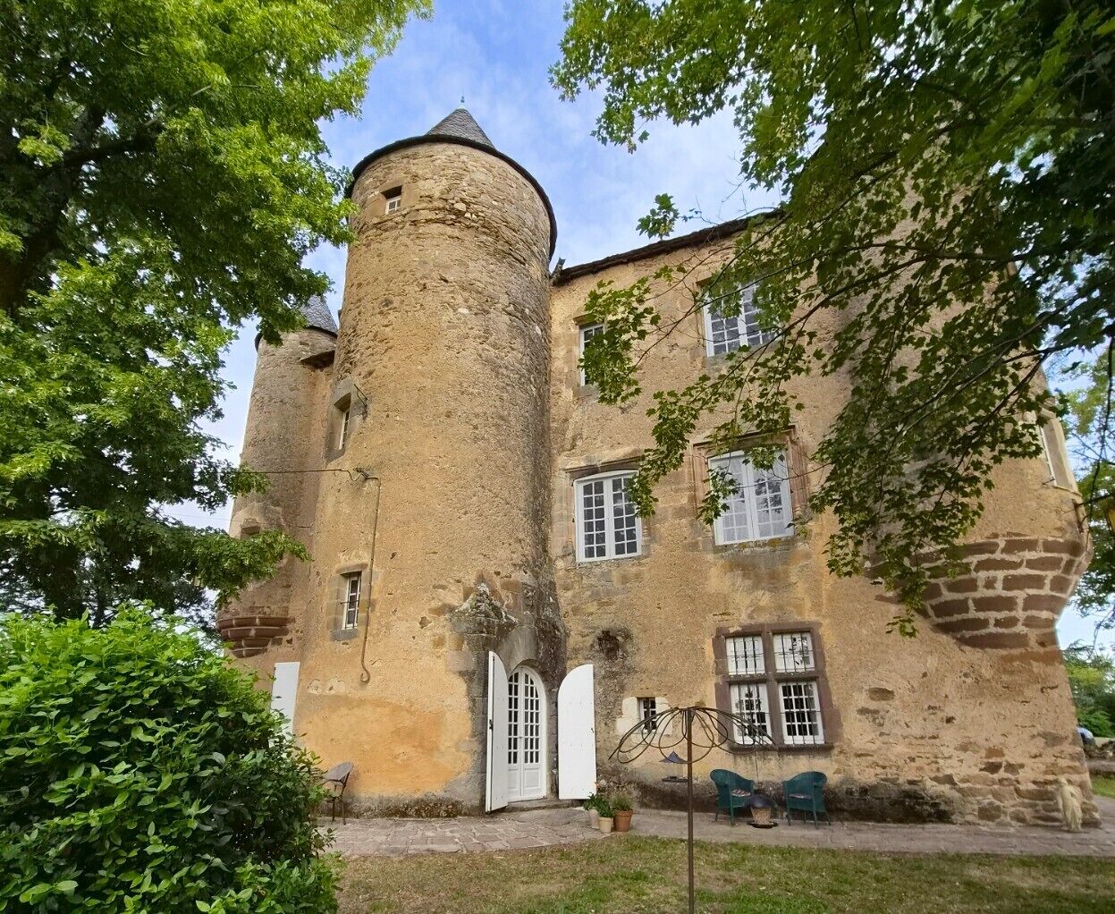 A historic building with a round tower, arched doorways, and a stone facade.