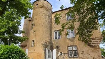 A historic building with a round tower, arched doorways, and a stone facade.