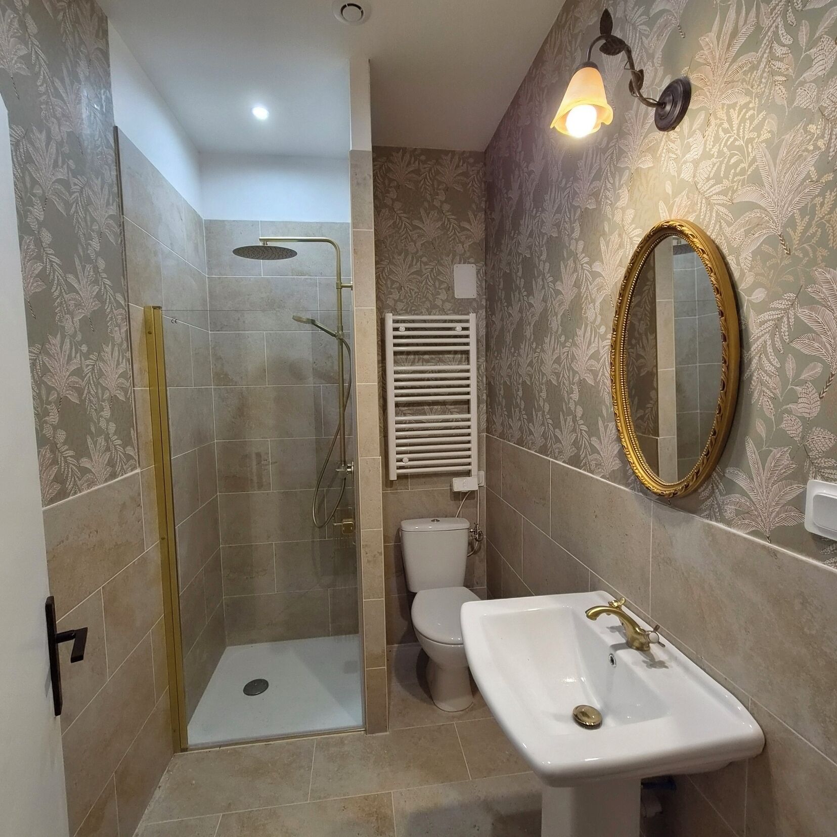 Un baño con ducha, inodoro, lavabo y espejo.