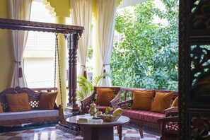 Una habitación tradicional con un conjunto de sofá, una mesa de centro y un sillón colgante.