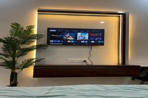 A flat-screen TV mounted on a wall with a wooden cabinet below.