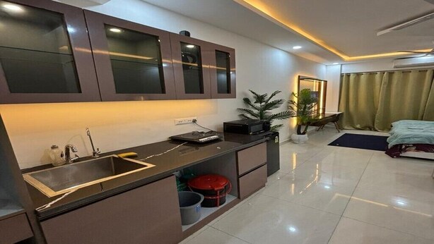 A modern kitchen with a built-in sink, cabinets, and a small countertop. - Tranquil studio with AC in enjoyable Greater Noida location (Greater Noida)