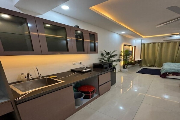 A modern kitchen with a built-in sink, cabinets, and a small countertop.