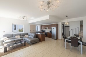 A modern apartment with a living room, kitchen, and dining area. - Ayia Napa Holiday Villa SV11 (Ayia Napa)