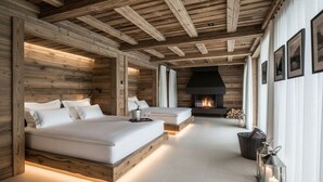Una habitación con techo de madera, chimenea, dos camas y un pasillo con faroles.