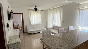 Eine moderne Küche mit Granit Arbeitsplatte, integriertem Backofen und einem Essbereich mit weißem Tisch und Stühlen.