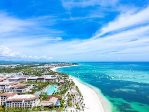 A resort with multiple buildings, a beach, and clear turquoise waters. - Affordable 2BR Apartment w Pool Punta Cana (Punta Cana)